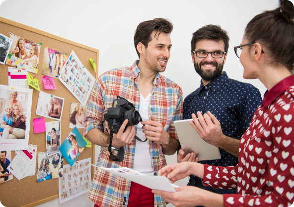 Three people smiling with a whiteboard in the background