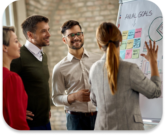 People gathered smiling and looking at a whiteboard