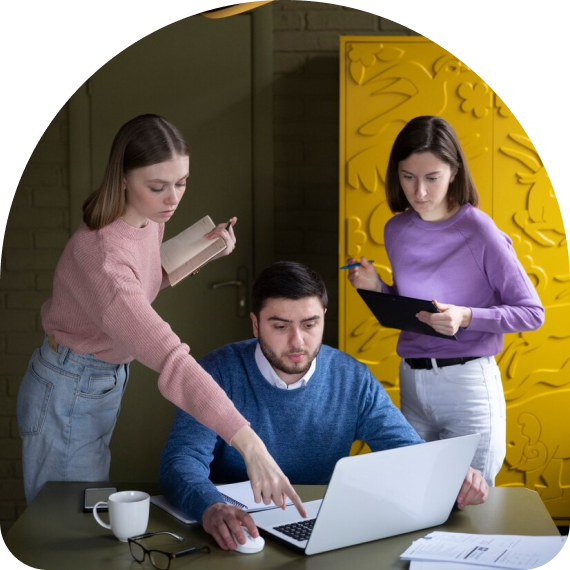 Three people looking at a notebook