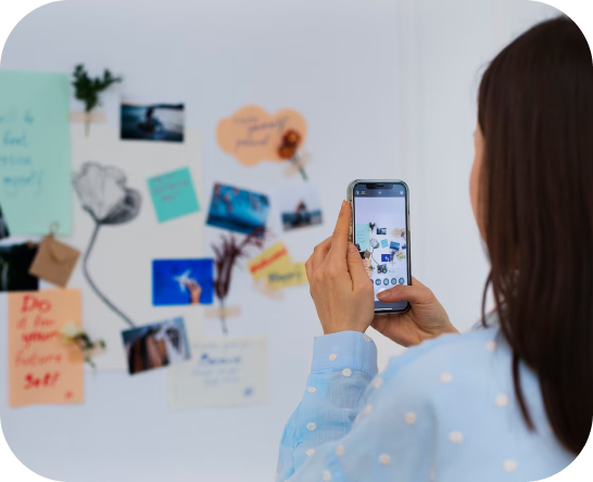 Person taking a picture of a wall that has a concept map/mind map on it